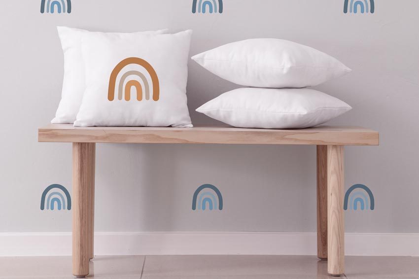 Schablonieren mit Wandschablonen - hier wurde eine helle Wand mit kleinen bunten Regenbögen für ein Kinderzimmer gestaltet.